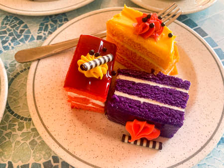 Various colored cakes on plates. sweet desserts. photo