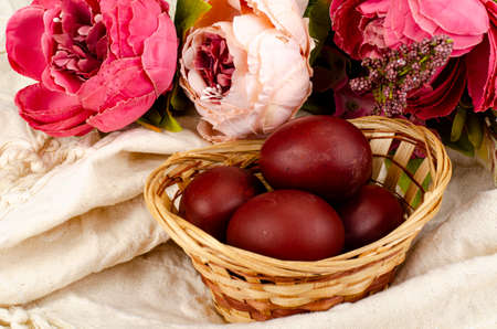 Wicker bowl with red hand-painted easter eggs. photoの写真素材