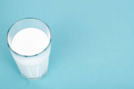 Glass of fresh white milk on blue background. Studio Photo.の写真素材