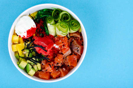 Poke with sea food and vegetables on blue background. photoの写真素材