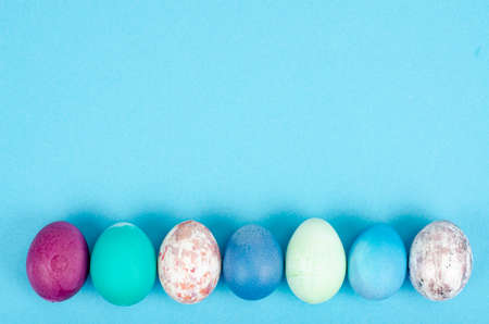 Decorated handmade Easter eggs for the holiday season on blue background. Creative minimal abstract concept. photoの写真素材