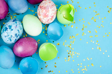 Decorated handmade Easter eggs for the holiday season on blue background. Creative minimal abstract...