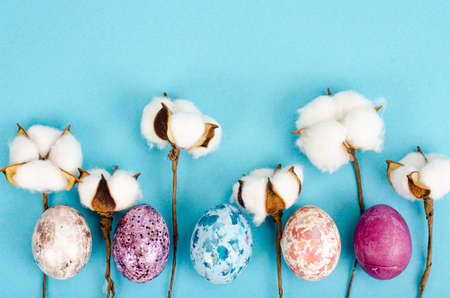 Easter background, color handmade eggs on blue background, decorated with cotton, space for text. happy holiday. photoの写真素材