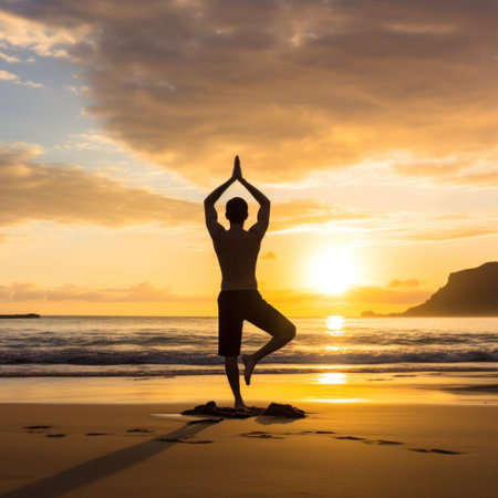 A man doing yoga on a beach, with the ocean and sunrise in the background.の素材