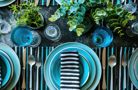 blue and white dinner table setting with plate and plants.の素材