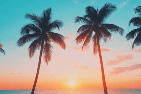 A stunning sunset paints the sky in vibrant hues of pink and orange, silhouetted by palm trees. The tranquil mountains provide a serene backdrop, signaling the end of the day in a tropical paradise.の素材