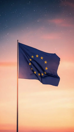 The European flag flutters gently on a flagpole as the sun sets, casting a warm glow over the scene. Stars begin to appear in the darkening sky, creating a serene atmosphere.の素材
