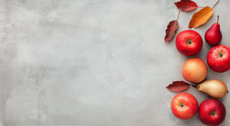 A cluster of shiny red apples and yellow pears is displayed on a light gray surface, with one apple sliced open to show its interior. The layout emphasizes freshness and color.の素材