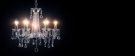 A beautifully crafted crystal chandelier hangs from the ceiling, casting a warm glow in the dark space.の素材