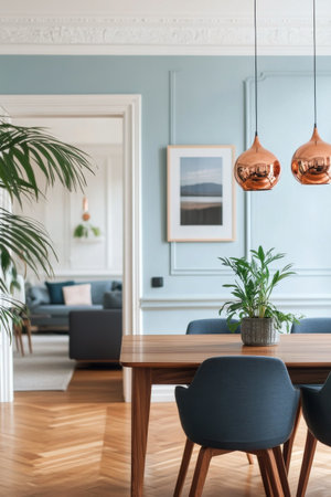 This inviting dining space features a wooden table surrounded by modern chairs, complemented by contemporary pendant lights. A plant adds a touch of greenery.の素材