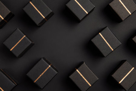 Small black gift boxes with gold accents are neatly arranged on a dark surface, creating an elegant display perfect for a celebration or special occasion.の素材