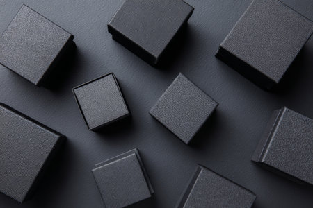 Black gift boxes with elegant bows are neatly arranged on a dark surface, creating a sophisticated display ideal for a celebration or special event..の素材