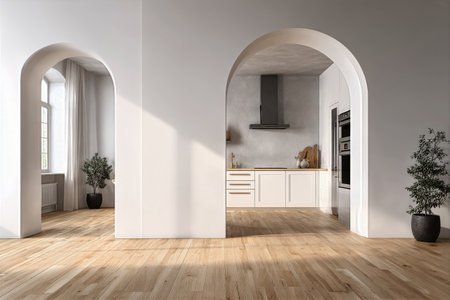 Spacious living area features white walls and arches leading to a modern kitchen. Bright sunlight fills the room, highlighting wooden floors and decorative plants in pots.の素材