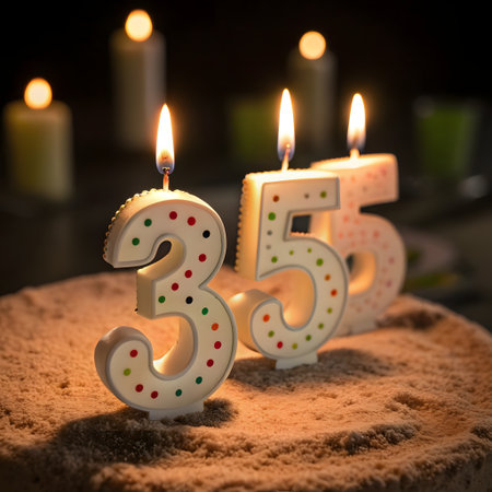 Birthday cake with candles number 35 fifty five lit on dark backgroundの素材