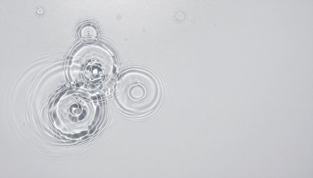 Aqua surface with rings and ripples flat lay on white background capturing calm water texture, perfect for spa themes, wellness branding, nature backgrounds, product mockups, and modern designの素材