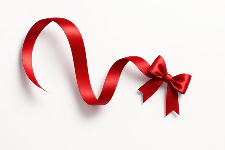 Isometric overhead red satin ribbon in a flowing s curve with a small offset bow along the arc elegant gift wrap design isolated on whiteの素材