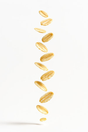 Levitating oat flakes forming a loose helical column from top to bottom on whiteの素材