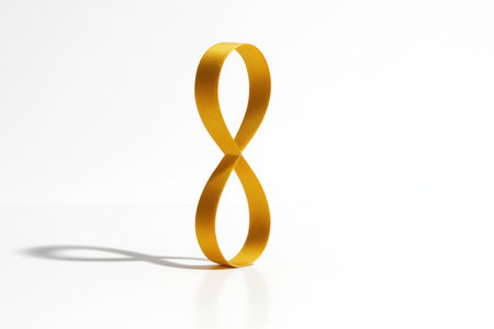 Golden ribbon balanced upright forming a tall figure eight loop perfect symmetry isolated on pure white minimal product shotの素材