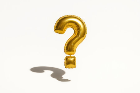 Bright gold question mark balloon with smooth metallic sheen floating slightly above the surface studio on whiteの素材