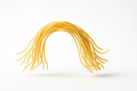 Flying wheat noodles arcing in mid air above a matte white surface graceful food motion studio on whiteの素材