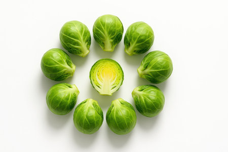 Top down fresh Brussels sprouts arranged in a clean circle with one crisp cross section at the center bright produce visual on whiteの素材