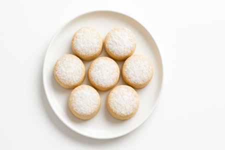 Traditional Spanish mantecados Christmas shortbread cookies in a neat circle on a matte white plate perfect for festive food brandingの素材