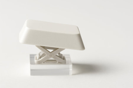 White computer enter key side profile close up with scissor mechanism visible on a clear acrylic riser on whiteの素材