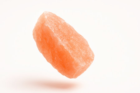 Big pink salt crystal suspended mid air on pure white background with gentle rotational tilt frozen motion for mineral food spa and creative design usesの素材