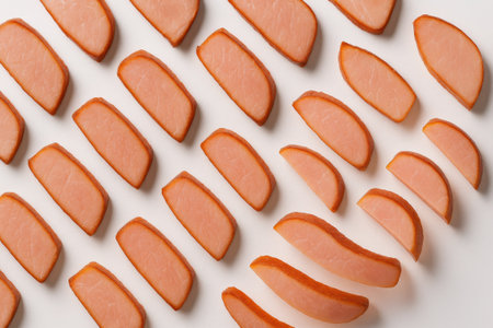 Sliced smoked ham in chevron pattern top down diagonal on white background for deli meat charcuterie platter restaurant menu and packaging themesの素材