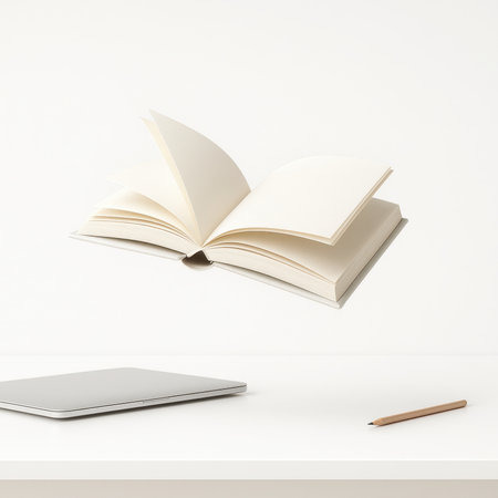 Open hardcover book hovering above a simple white desk with laptop and pencil on a clean background creative study workspace concept for education design and productivity themesの素材