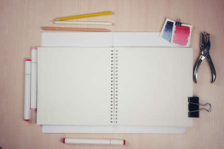 Photo of a desktop, an artist with a sketchbook on rings and markers