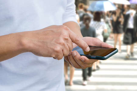Close up of a man using mobile smart phone outdoorの写真素材
