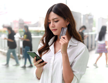 Ladies think before making a purchase in order to limit spendingの写真素材