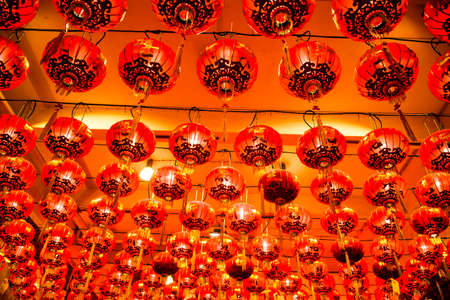 Red Chinese lanterns hang from the ceiling for people to worship and pray for good luck and blessings.の写真素材