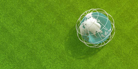 An orb with a cage around it, to protect it, placed on the green grass outdoors. globe, siege,...