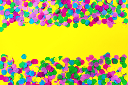 Multicolored confetti on a yellow background. Festive concept.の写真素材