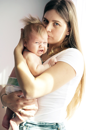 Mom and newborn baby in her arms. The concept of new life, love and helplessness. Lips bowの写真素材