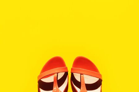 Orange fashionable womens sandals on a pink background. Concept of vacation and summer. Space wallpaper. Summer colorの写真素材