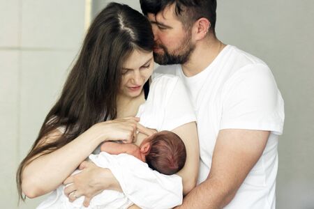 Father and mother with a newborn son. New young multi-generation family. Breast-feedingの写真素材
