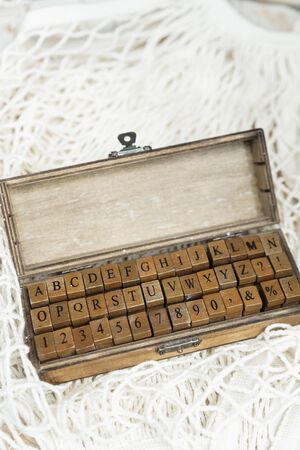 Set of wooden stamps of the English alphabet and numbers in a wooden box.