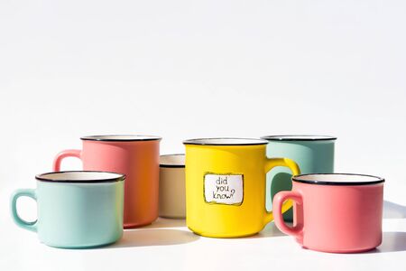 Several multi-colored coffee cups and one yellow with the inscription Did you know. Creative idea backgroundの写真素材
