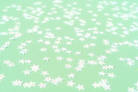 Light pink pearl stars on a mint pastel background. Holiday concept