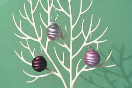 Christmas tree made of white plastic deer horns and bauble decoration on the deep green color...