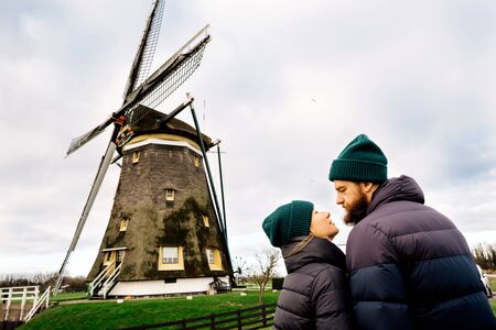 Loving couple man and woman face to face looking into each others eyes the background of the mill. Rural spring landscape. Family Relations and Valentines Day Conceptの写真素材