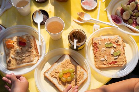 Edible sandwich made of white wheat bread, jam, peanut butter, fruit bananas and marmalade sweets. Children's holiday joint preparation. Festive Fun Food Conceptの写真素材