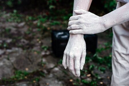 A pair of elegant female hands in dried clay on a white background. Ceramics production. Creativity and hobby concept.の写真素材