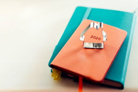 A cookie cutter in the shape of a house standing on the diary of 2020. Accounting for income and expenses, family budget. The warmth of the hearth. Mortgage repayment concept. Cozy homeの写真素材