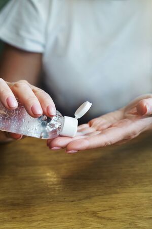 Woman in cafe treats hands with disinfectant antiseptic as prophylaxis the fight against coronavirus infection. The concept of personal hygiene in public places. Measures against the spread of virusの写真素材