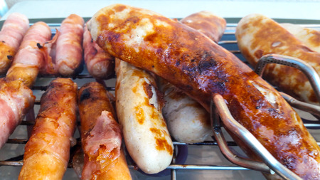 Grilling tasty sausages on barbecue grill eatの写真素材