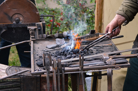 Blacksmith working on metal medieval fire iron hammer work